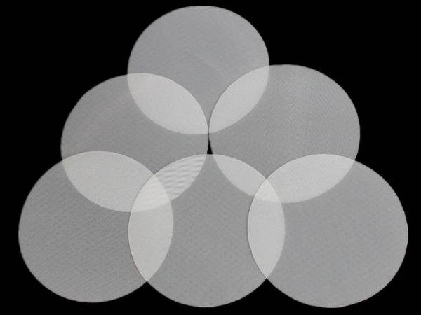 Several pieces of nylon mesh filter discs on black background.