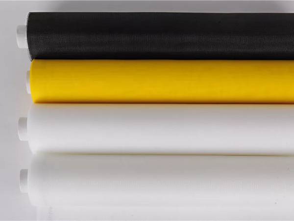 Four rolls of polyester filter mesh fabric in white, yellow and black color.